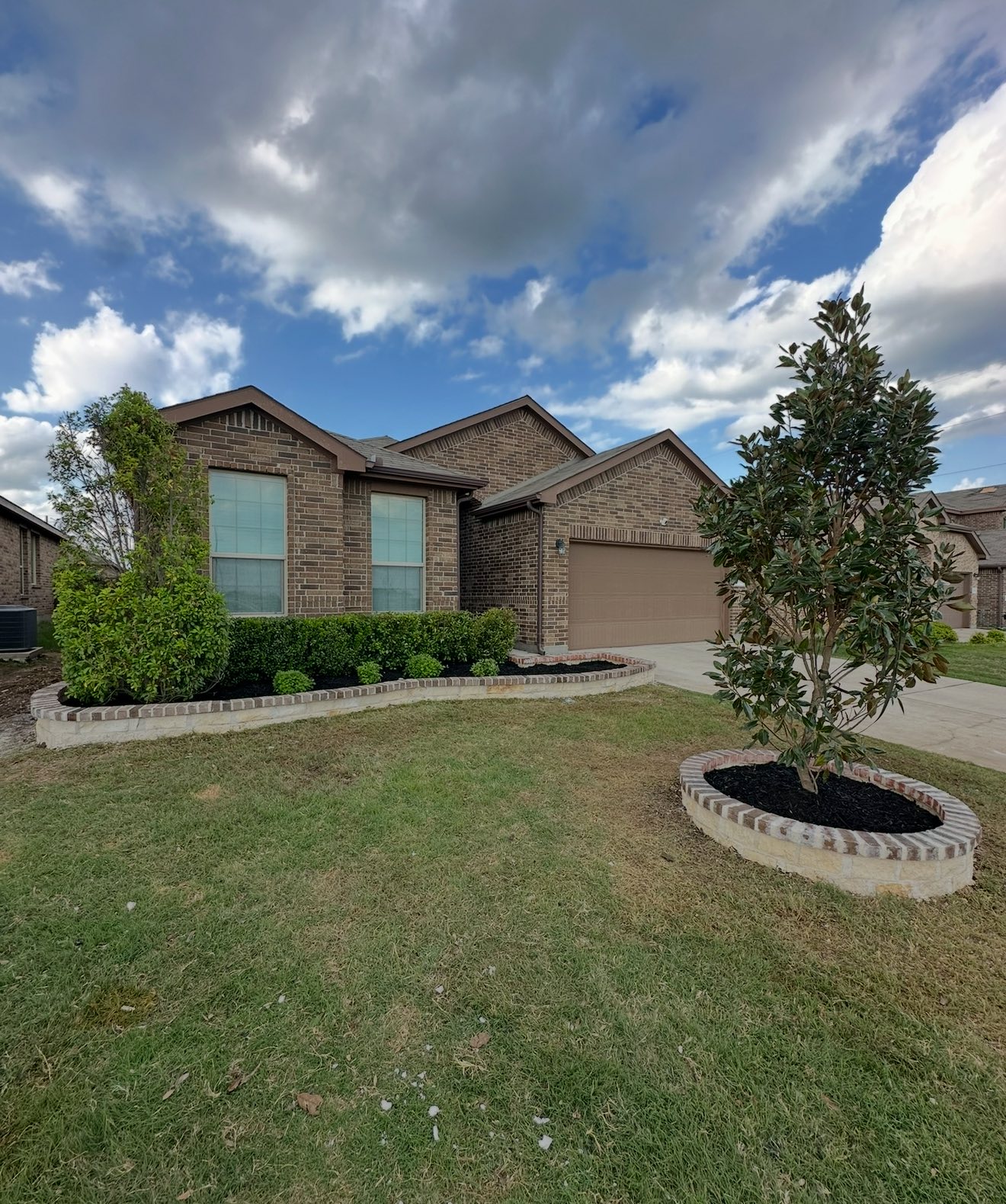 Front yard landscape design with trees and raised beds